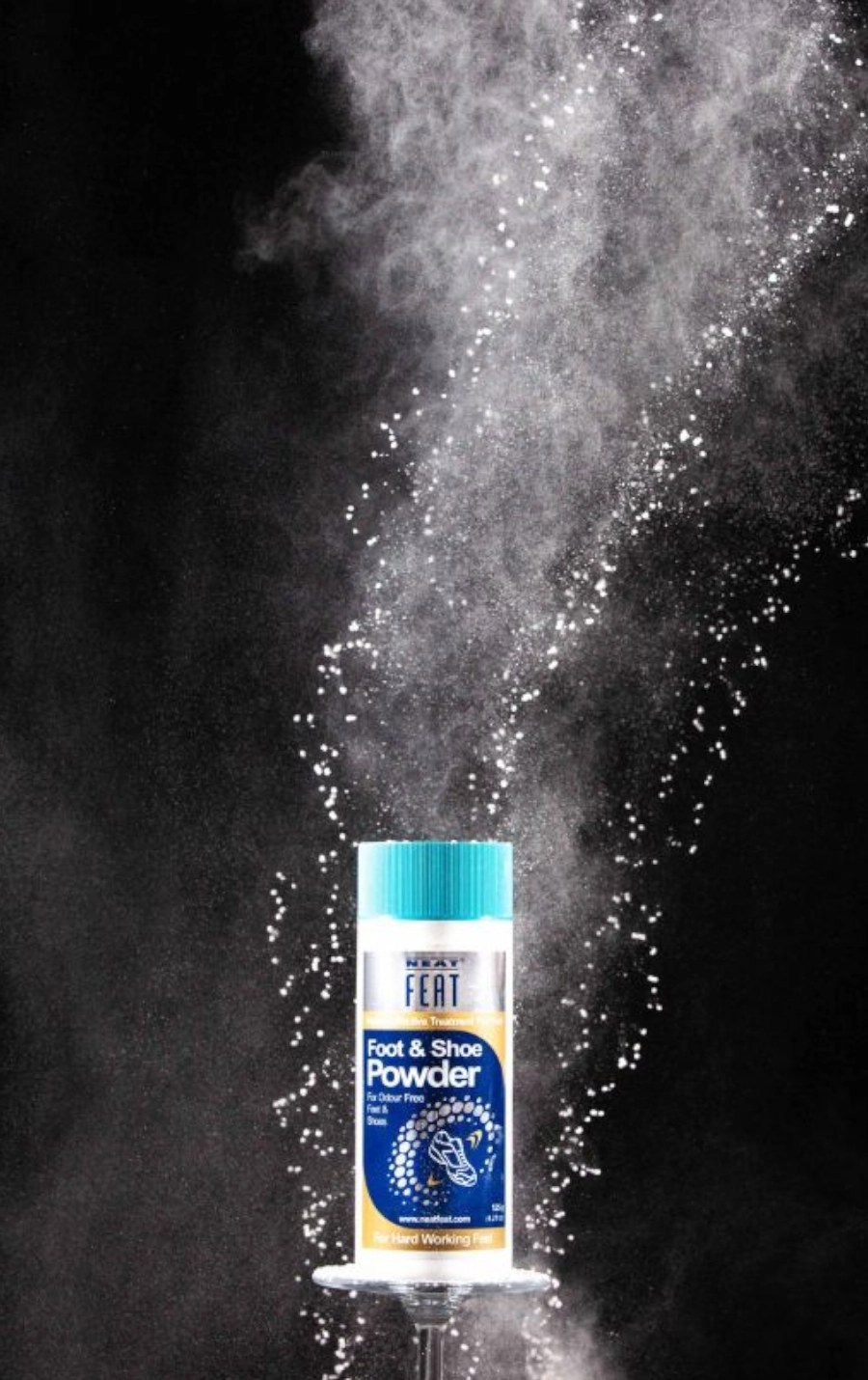 Neat Feat Foot & Shoe Powder in a burst of powder against a black background