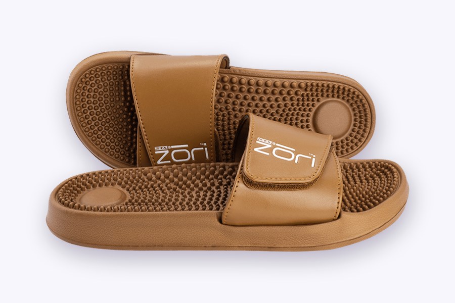 A pair of tan Neat Zori orthotic massage slides from Neat Feat