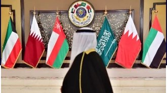 GCC delegate at a regional summit with GCC member nation flags